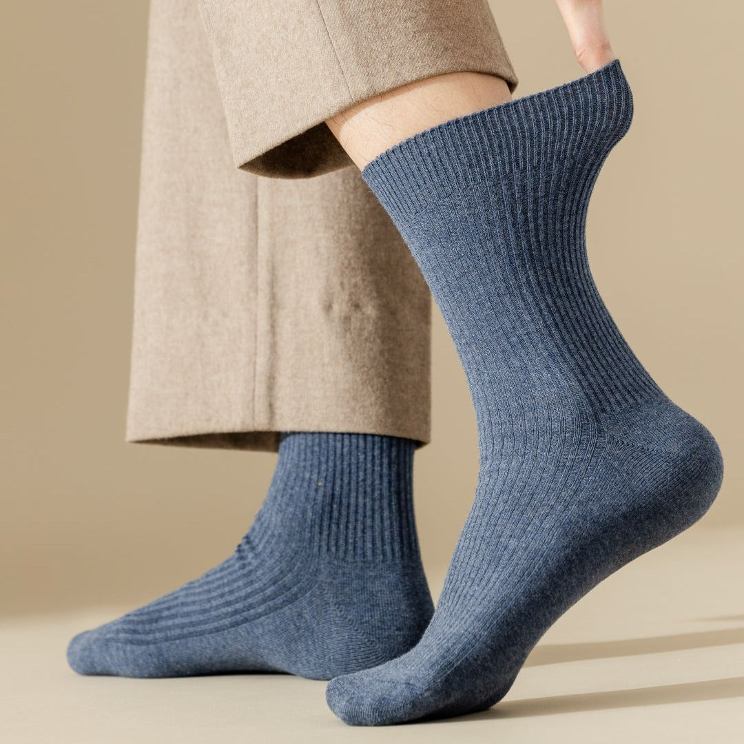 Person wearing blue socks with a beige background