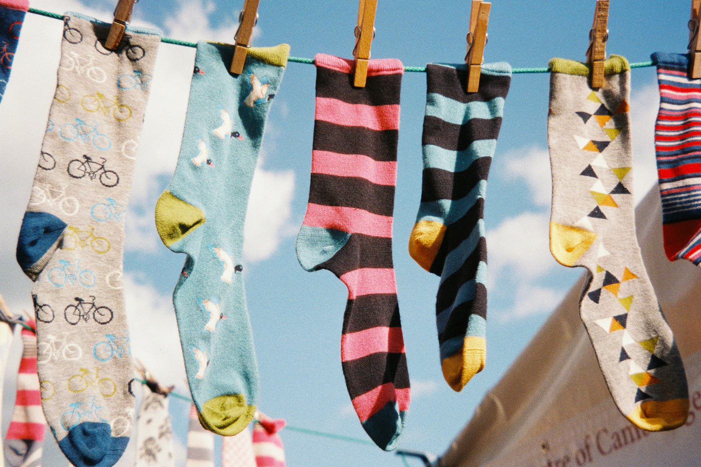 Colorful socks hanging on a clothesline with a blue sky background