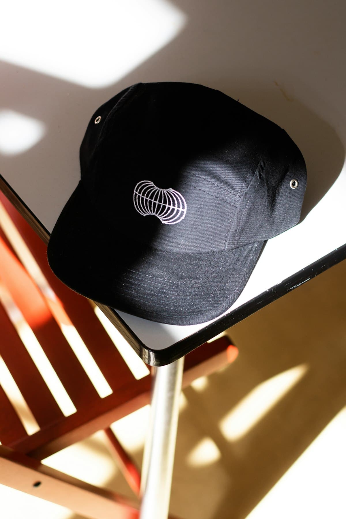 Black baseball cap resting on a chair