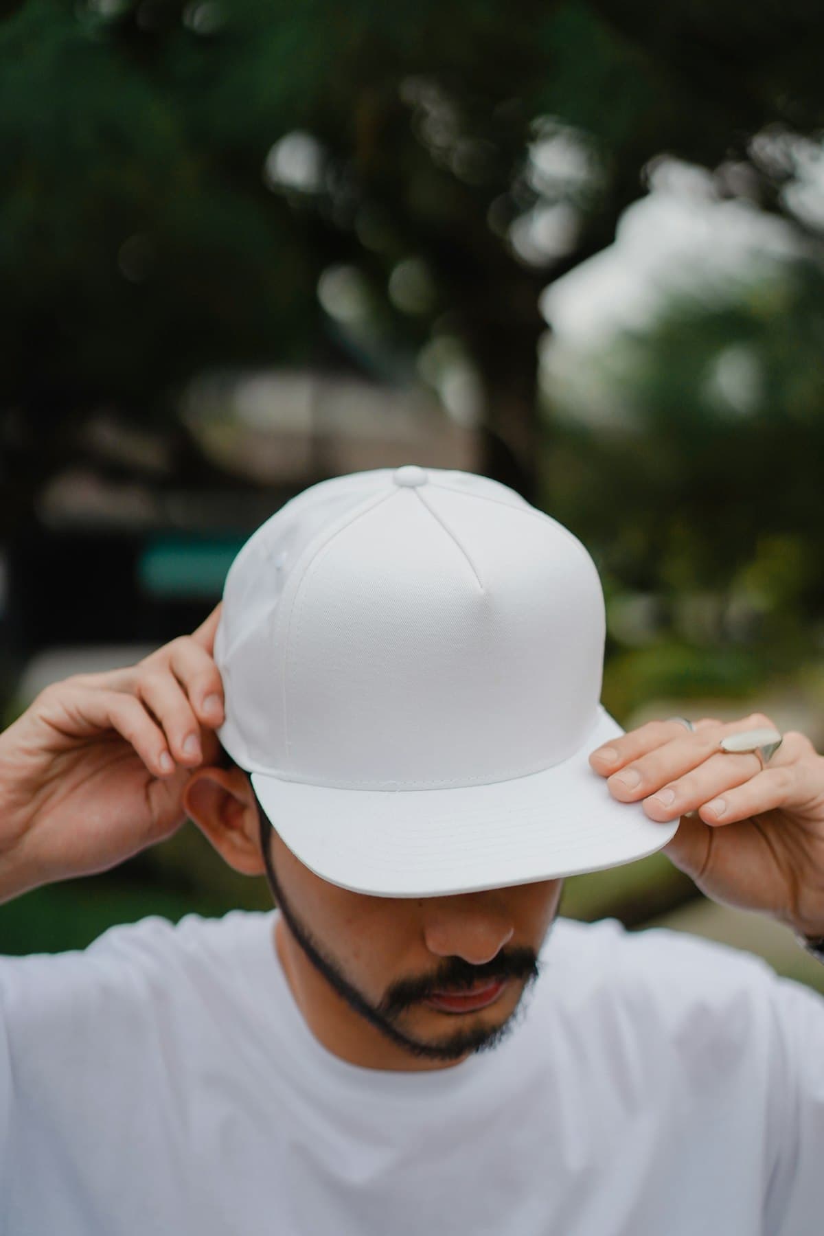 Man adjusting a white snapback